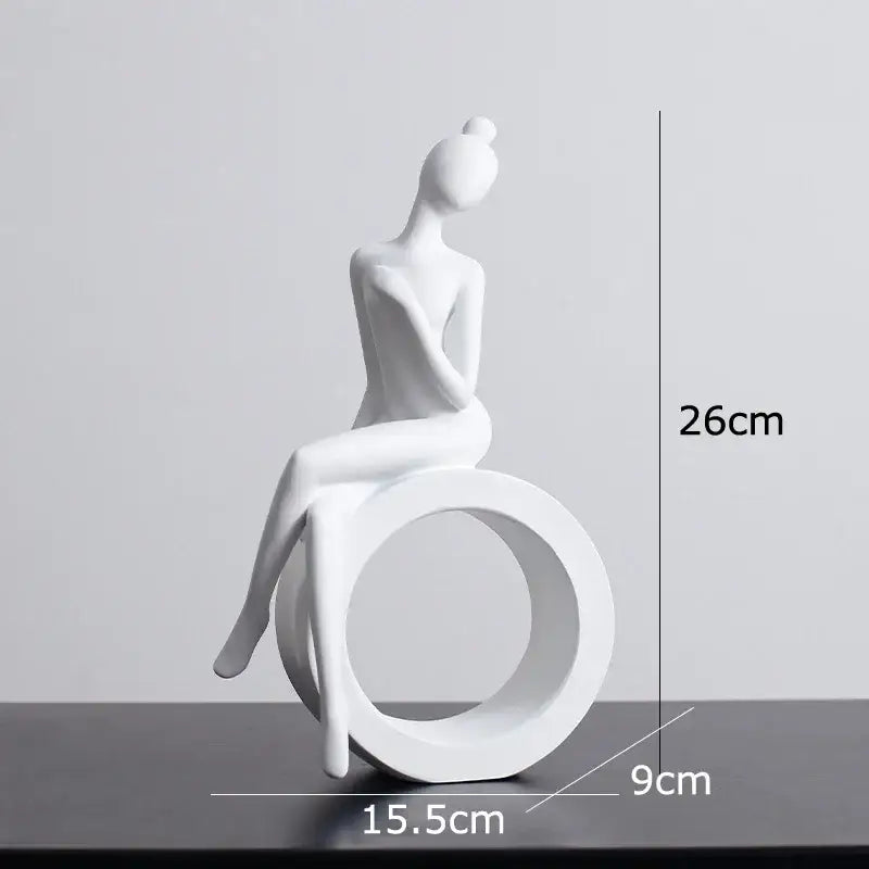 Minimalist white ceramic abstract figures sculpture of a seated woman with hair in a bun for living room decor