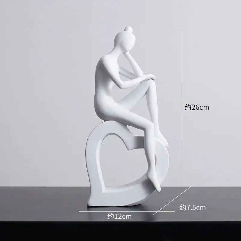 Minimalist white ceramic abstract figures sculpture of a seated woman on a heart-shaped base for living room decor