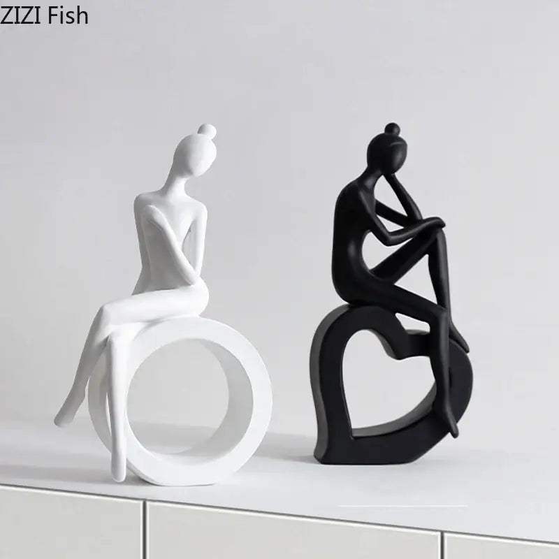 Two minimalist black and white abstract figures sculpture depicting stylized seated women for living room decor