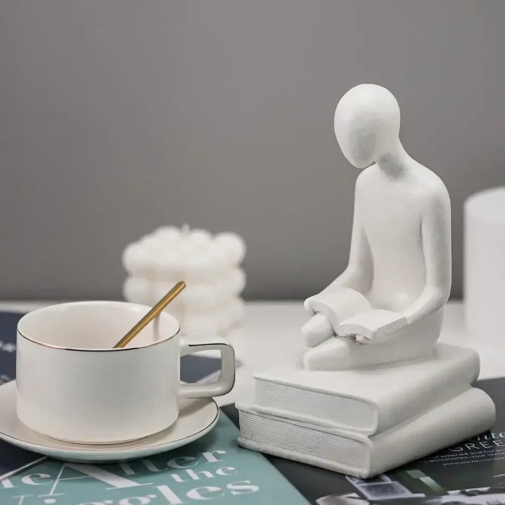 White ceramic minimalist abstract people resin statue of a seated figure reading for decorbites living room decor