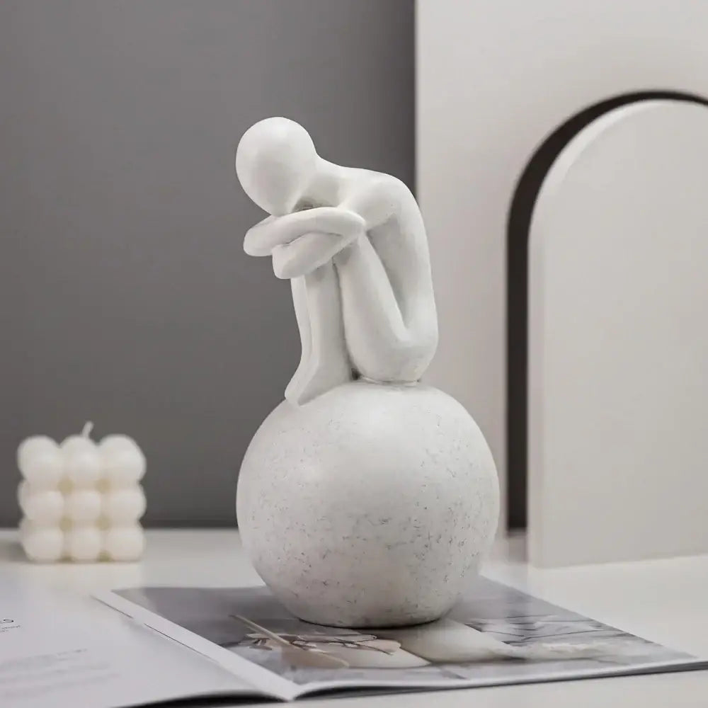 Minimalist white abstract people resin statue featuring a seated contemplative figure on a textured spherical base for decorbites abstract people living room decor