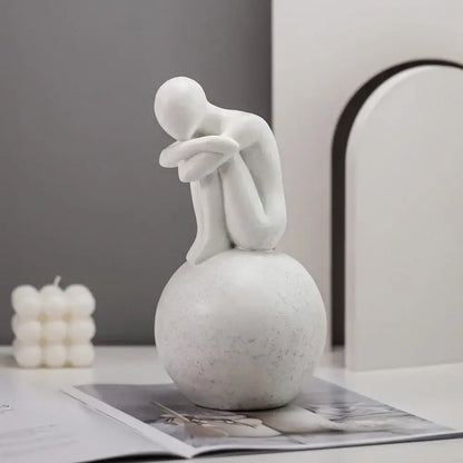 Minimalist white abstract people resin statue featuring a seated contemplative figure on a textured spherical base for decorbites abstract people living room decor