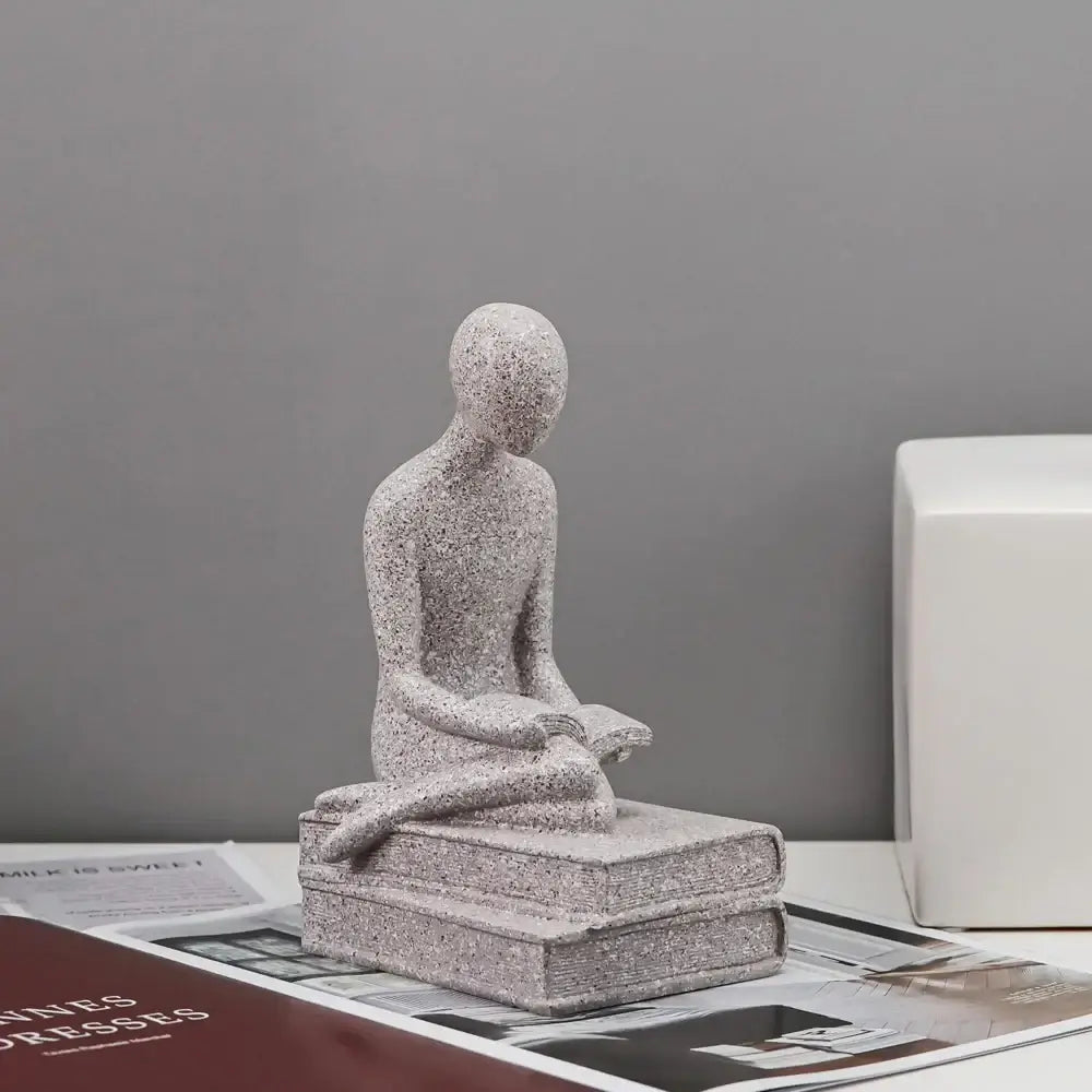 Gray speckled minimalist abstract people resin statue of seated human reading on stacked books for decorbites decor