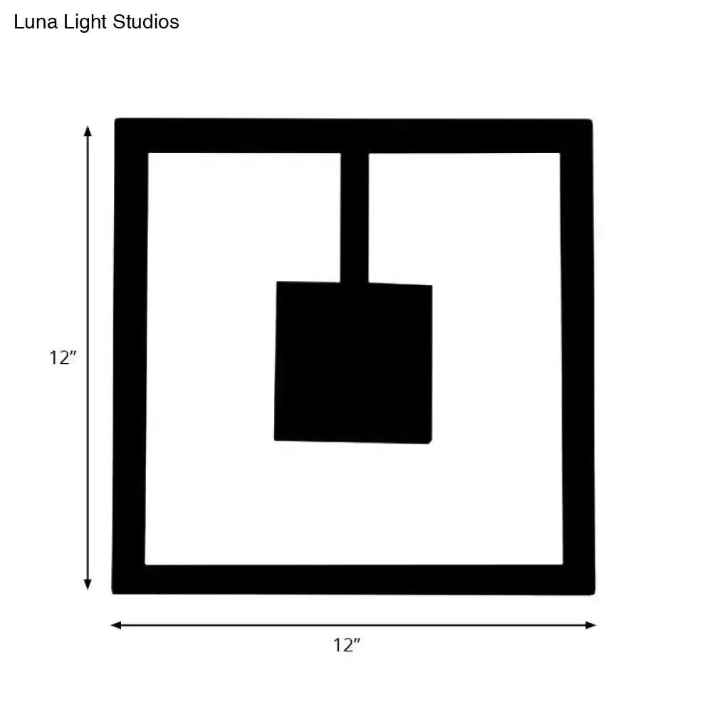 Black square minimalist wall art with hanging shovel silhouette paired with white acrylic direct wired electric light fixture
