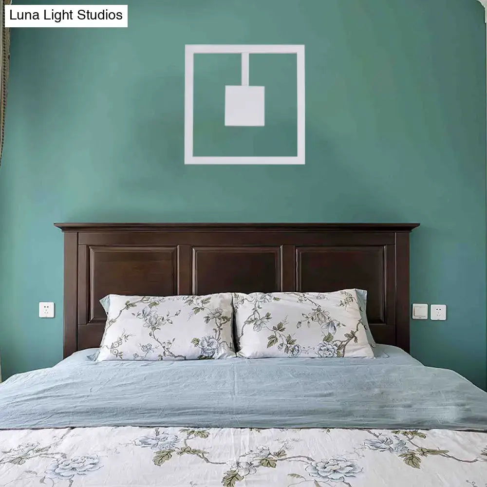 Minimalist white acrylic wall light fixture with geometric design above dark wood headboard direct wired electric maximum bulb wattage