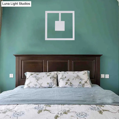 Minimalist white acrylic wall light fixture with geometric design above dark wood headboard direct wired electric maximum bulb wattage