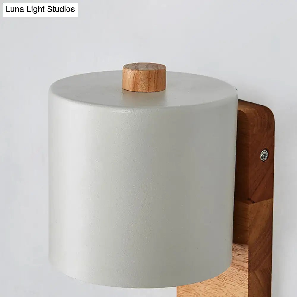 Minimalist white and green nordic wall sconce with matte off-white ceramic body and natural wood knob mounted on wooden bracket