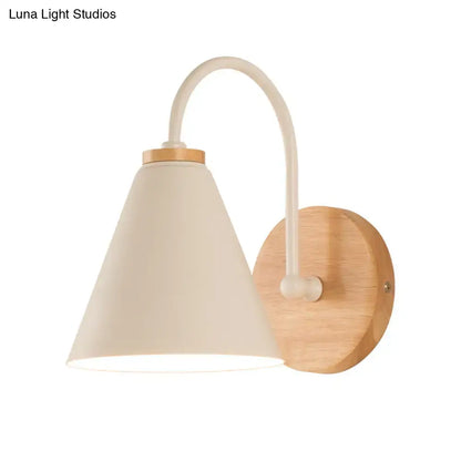 Minimalist wall sconce with cream conical lampshade, curved white metal arm, and natural wood base wall light for bedroom