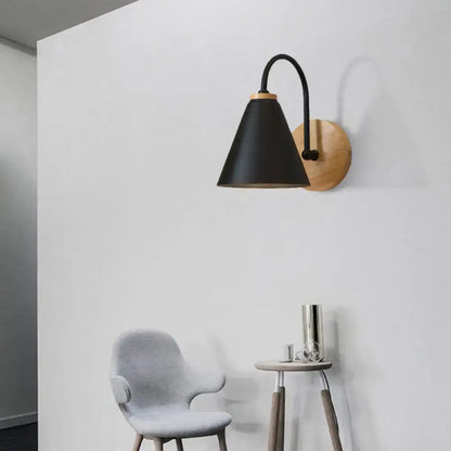 Minimalist black conical wall sconce with curved metal arm and natural wood backplate for bedroom wall light use