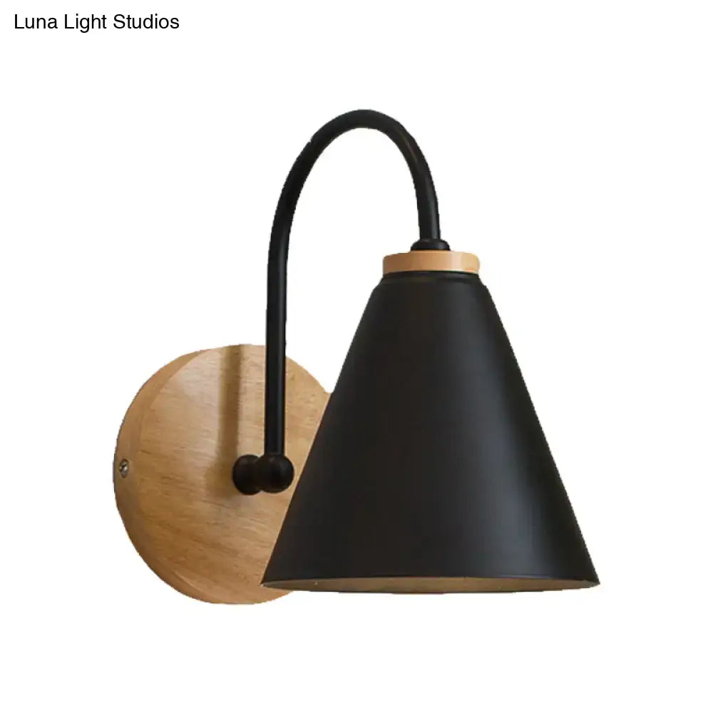Black matte conical wall sconce with curved metal arm and natural wood backplate for minimalist bedroom wall light