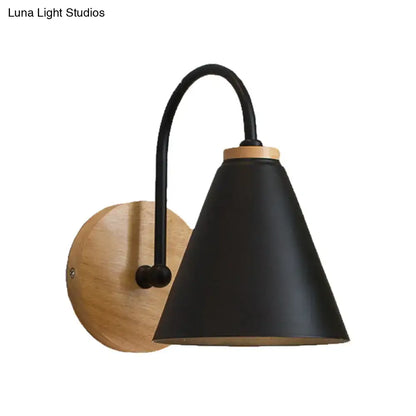 Black matte conical wall sconce with curved metal arm and natural wood backplate for minimalist bedroom wall light