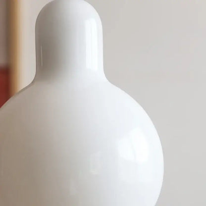 A sleek white ceramic led pendant lamp with a rounded minimalist design for dining room warm glow lighting
