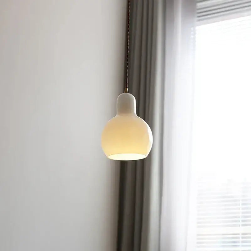 Minimalist off-white ceramic led pendant lamp with a rounded shape and warm glow for dining room lighting