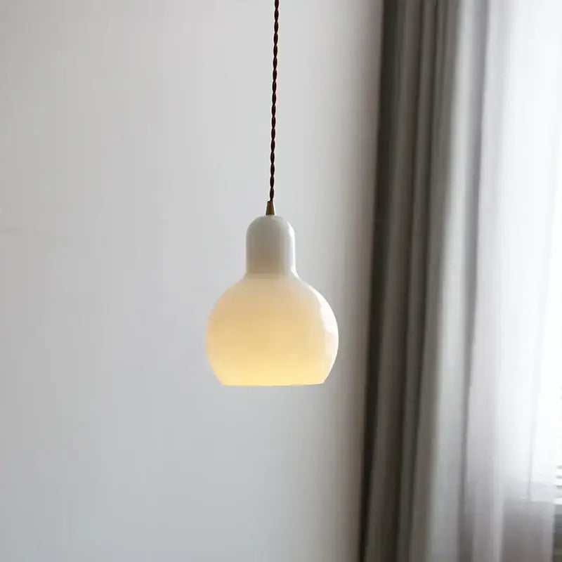 Minimalist white ceramic led pendant lamp with warm glow and twisted brown cord ideal for dining room lighting