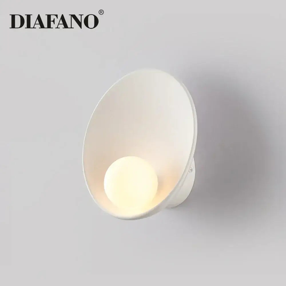 Minimalist white ceramic led wall sconce with a sleek conical design and warm-glowing bulb for bedroom lighting