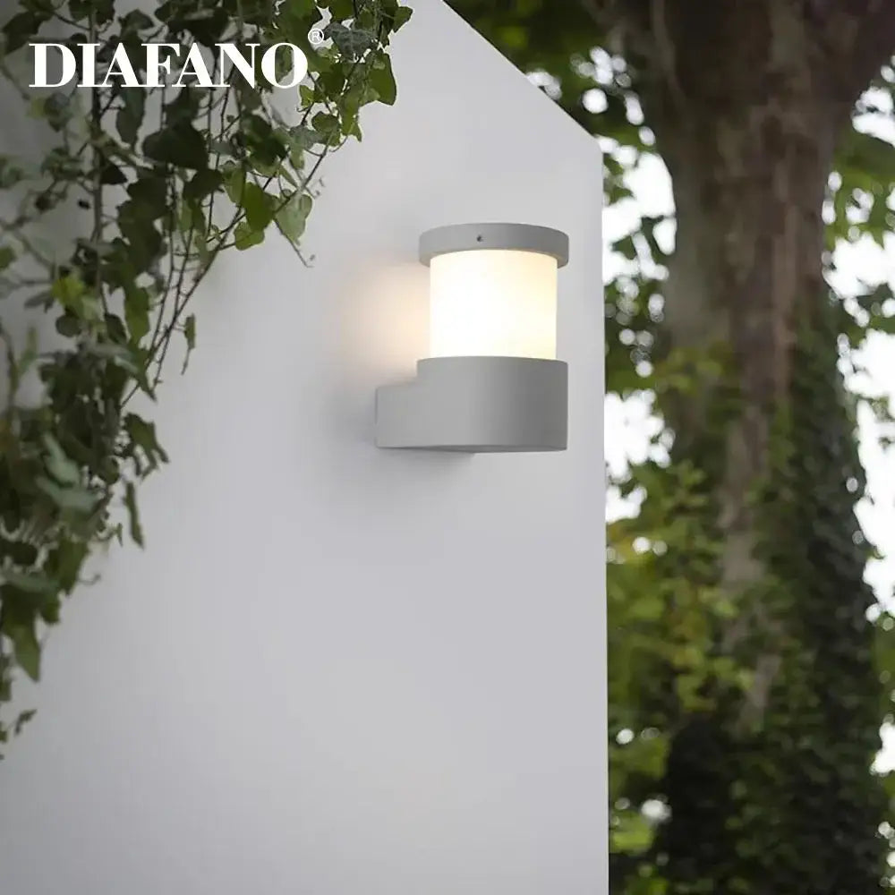 Gray cylindrical concrete outdoor wall lamp with frosted glass diffuser and diafano logo for decorbites concrete outdoor use