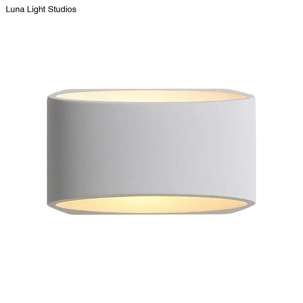 Minimalist white cylindrical led wall sconce with matte gray exterior and warm yellow interior as a sleek wall lamp