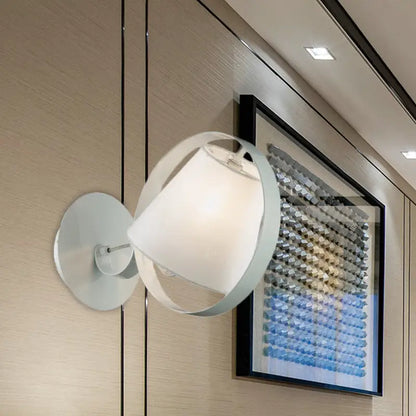 Minimalist white fabric wall light with metal ring and curved frame providing soft diffused lighting for bedrooms