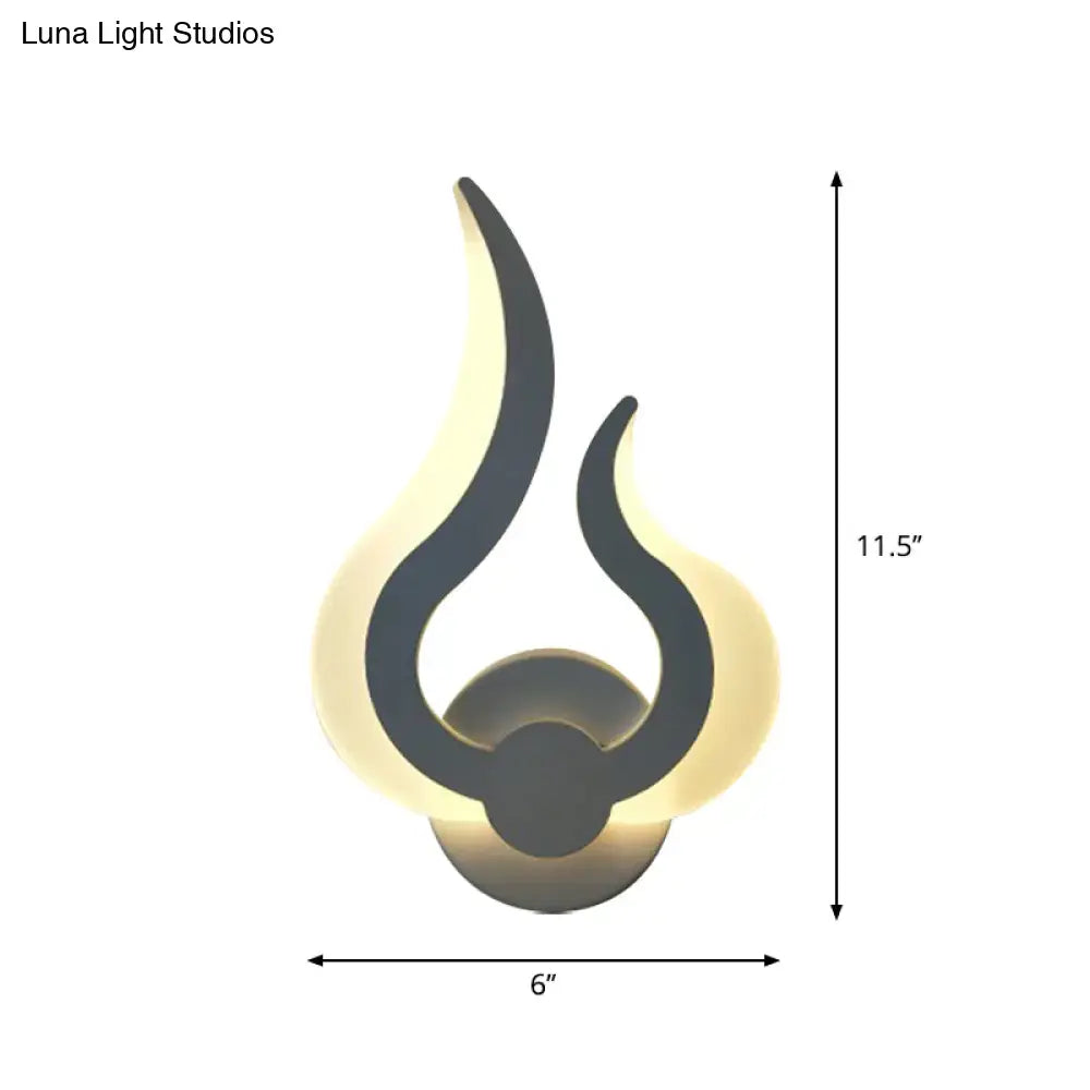Minimalist white flame wall sconce with sleek black silhouette and warm glowing LED light for bedroom ambiance