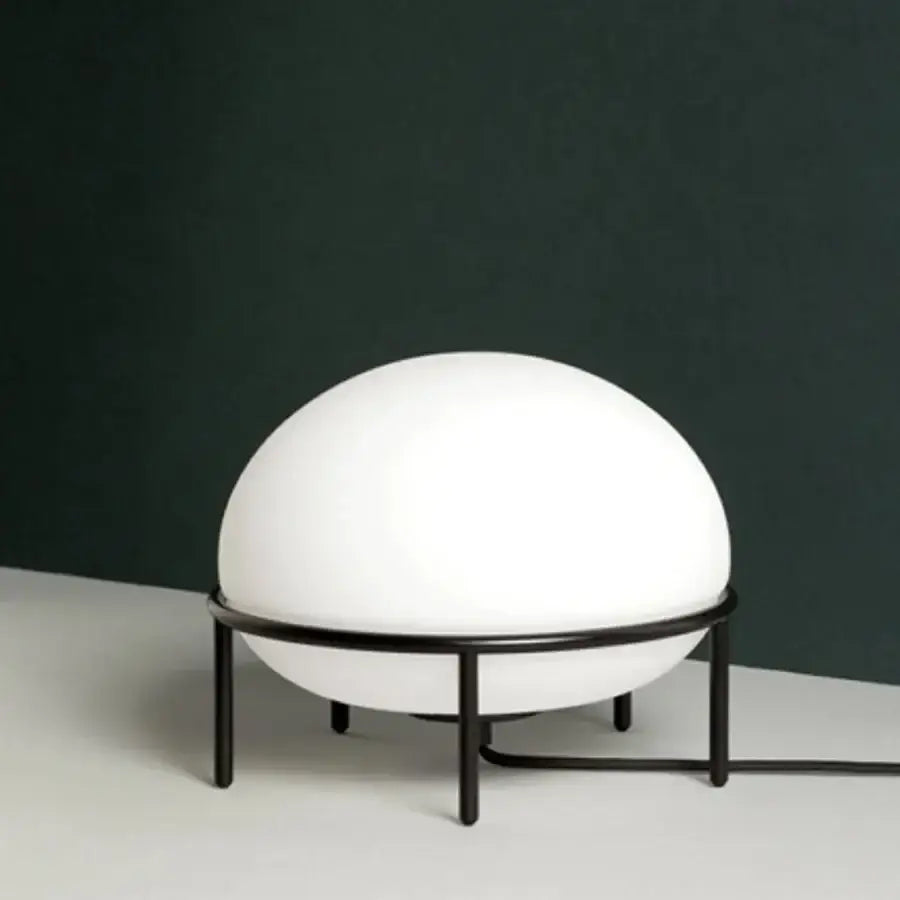Minimalist white glass ball table lamp with smooth spherical globe on black metal frame ideal for bedroom decorbites glass ball