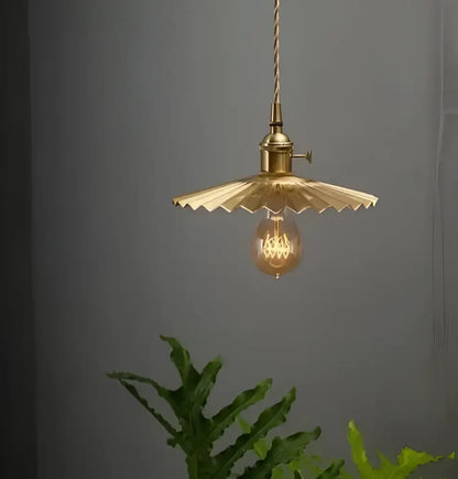 Minimalist brass pendant light with scalloped fan-shaped glass shade and exposed filament bulb for dining room