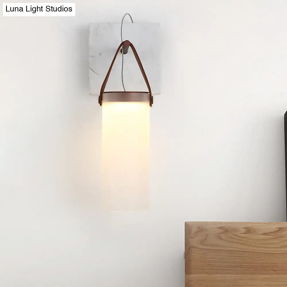 Minimalist wall light with white glass shade copper metal and leather strap on white marble backplate for bedroom