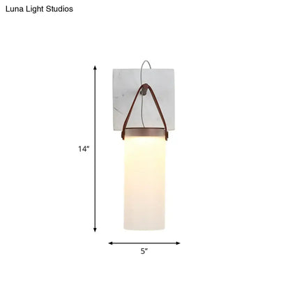Minimalist white glass wall light with leather strap featuring frosted glass and copper-toned metal for bedroom use