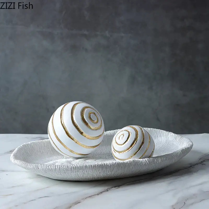 Minimalist white ceramic spheres with gold spiral stripes on a textured tray for geometric desk decoration and desk decoration