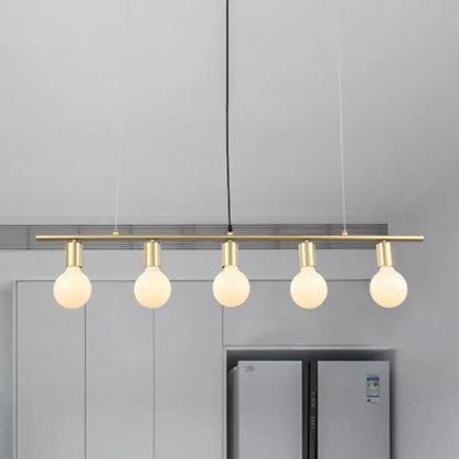 Modern white gold linear metal island lighting featuring a brass bar pendant light with five glowing spherical bulbs