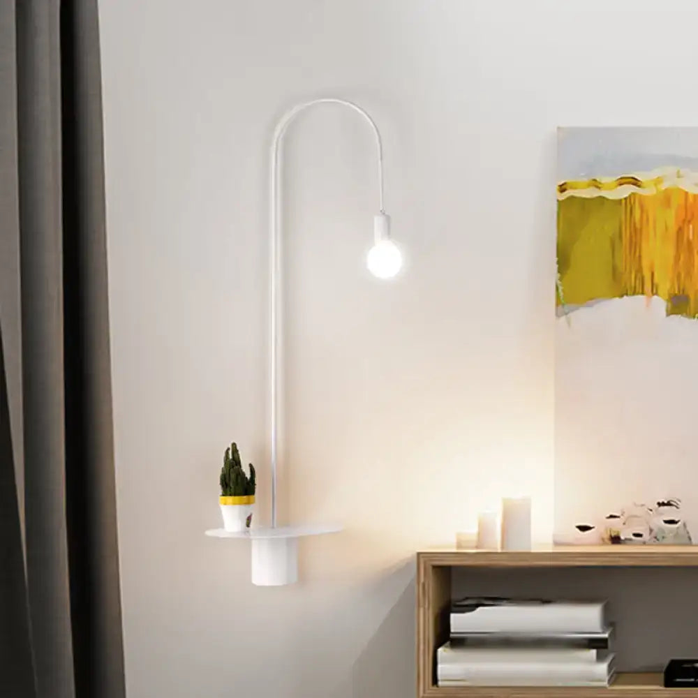 Minimalist white gooseneck wall sconce wall light with curved design and integrated shelf holding a small potted cactus