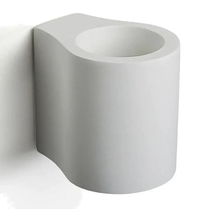 White ceramic wall-mounted toilet paper holder with sleek modern design complementing minimalist gypsum wall lamp