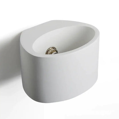 Modern white ceramic wall-mounted bidet with metallic faucet displayed alongside minimalist white and gray gypsum wall lamp