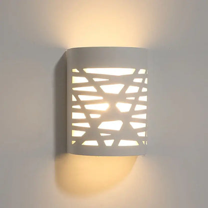 Minimalist white gypsum wall lamp with geometric cutout pattern providing diffused light for living room use