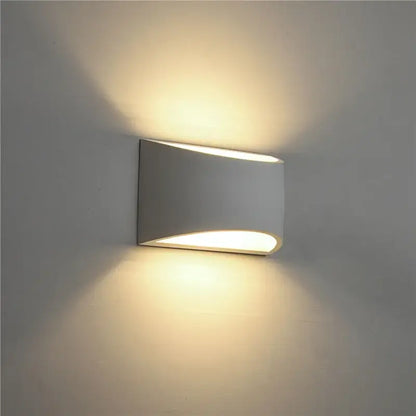 Minimalist white and gray gypsum wall lamp with sleek curved design and warm diffused light for living room