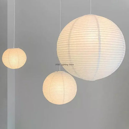 Minimalist white handwoven art pendant lamp with three spherical lanterns emitting a warm glow by decorbites handwoven art