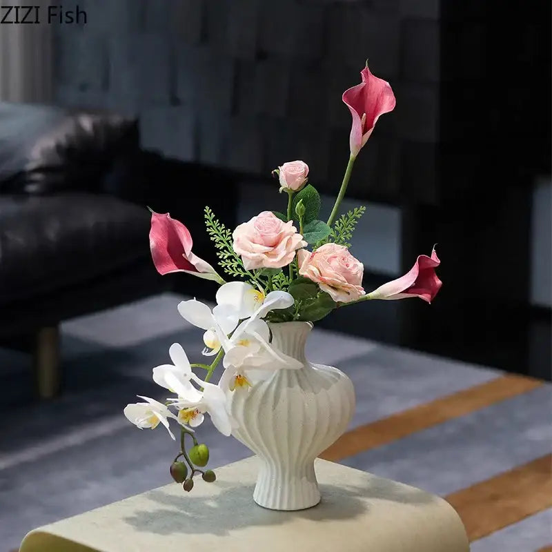Minimalist white heart shape ceramic vase with vertical ridges holding pink calla lilies and peach roses decorbites heart shape