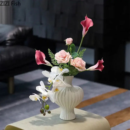 Minimalist white heart shape ceramic vase with vertical ridges holding pink calla lilies and peach roses decorbites heart shape