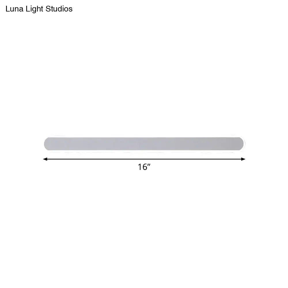 A sleek 16-inch silver metallic wall sconce providing warm white light for minimalist bathroom decor