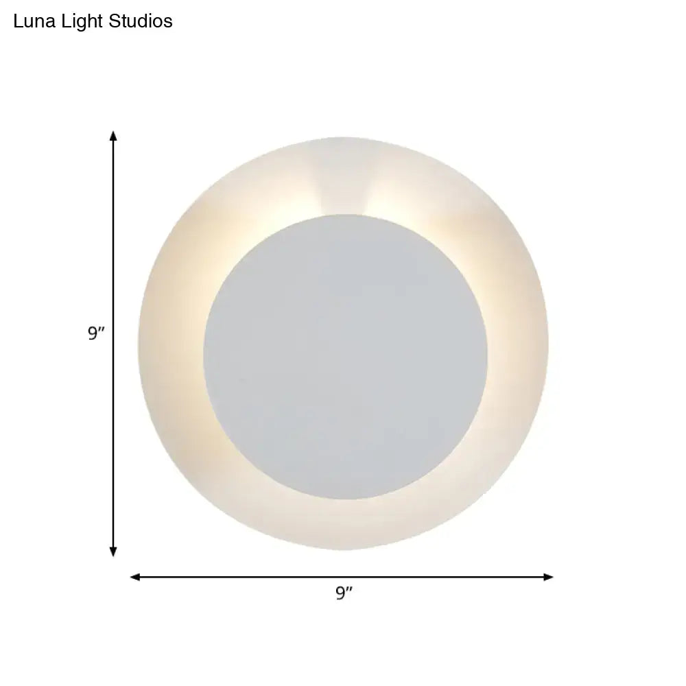 Minimalist white led wall sconce lamp with frosted glass ring and central mirror emitting soft warm light for bedroom use