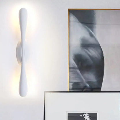 Minimalist white linear wall sconce lighting with smooth sculpted design emitting warm light for living room