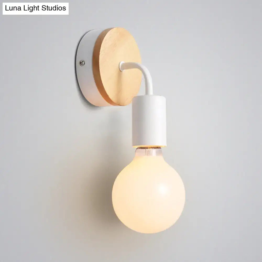 Minimalist bare bulb wall sconce with natural wood backplate and white metal arm for bedroom lighting