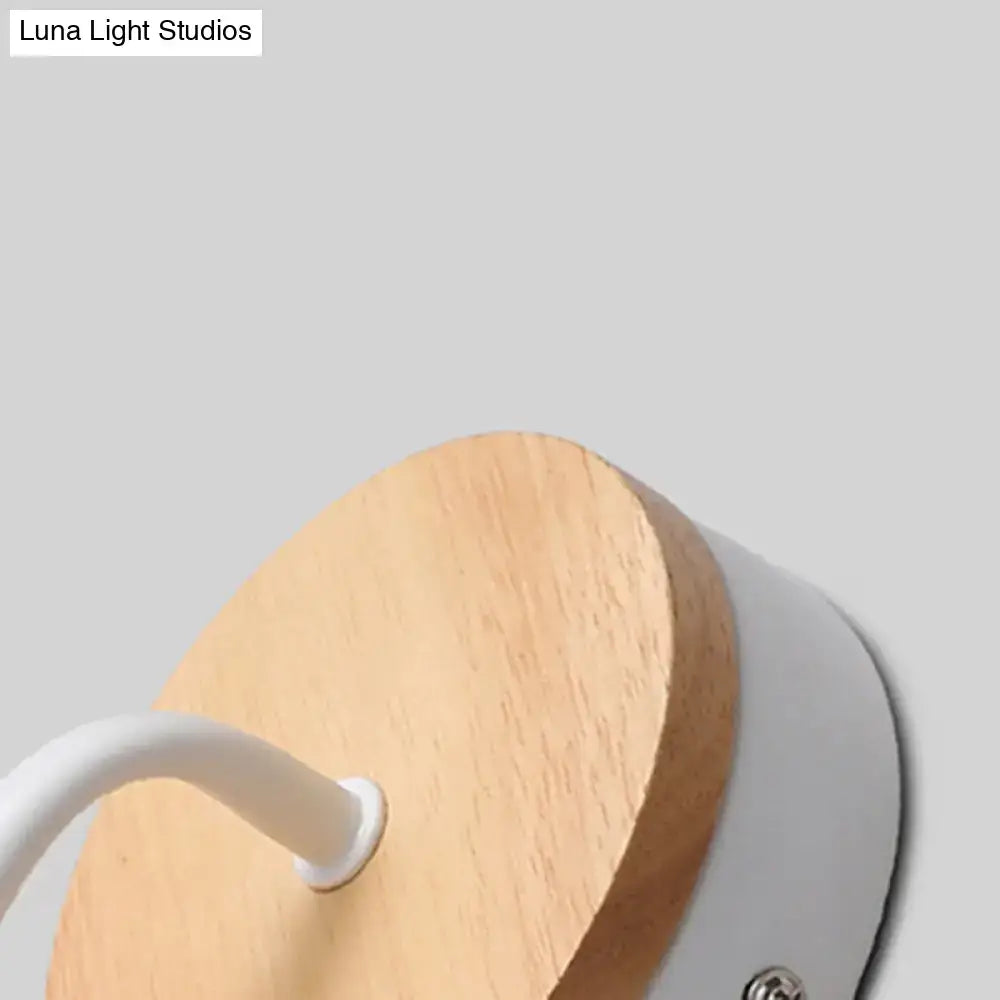 Minimalist white metal and wood bare bulb wall sconce with circular wooden base and sleek housing for bedroom lighting