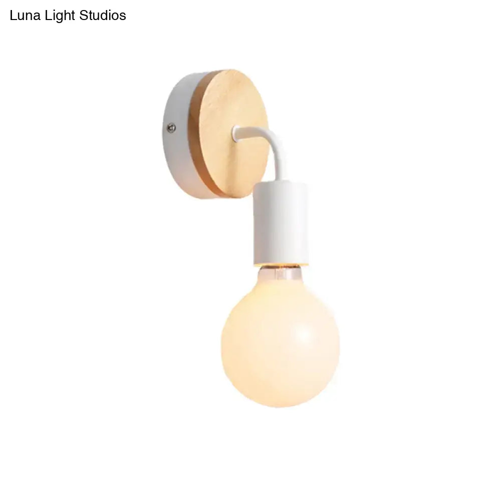 Minimalist bare bulb wall sconce with round wooden backplate and white metal trim for bedroom lighting