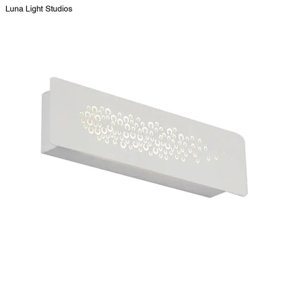 Minimalist white wall lamp with sturdy metal build and circular cutouts creating bubble pattern up and down light