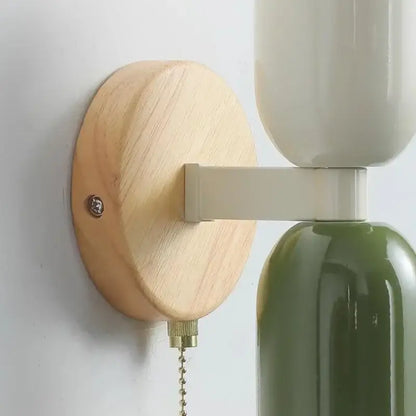Minimalist wall lamp with cream zipper wooden base, off-white and olive green ceramic shades, brass chain pull decorbites cream zipper