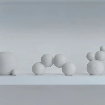 Minimalist white speckled geometric ceramic handicraft sphere sculpture with smooth matte gray surfaces and clustered design