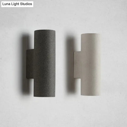 Two minimalist concrete wall sconces in dark gray and light beige with compact fixture height for stair use