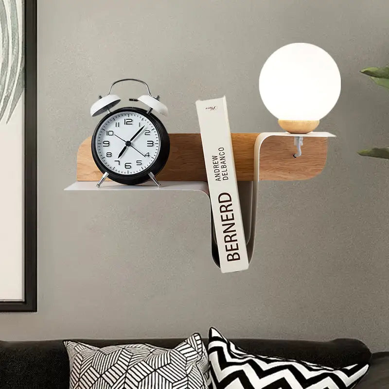 Minimalist white wall lamp with frosted glass shelf holding a wooden wall shelf with alarm clock and book for bedroom use