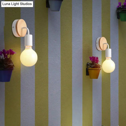 Minimalist white and wood wall sconce featuring warm-toned direct wired electric globe bulbs for bedroom lighting