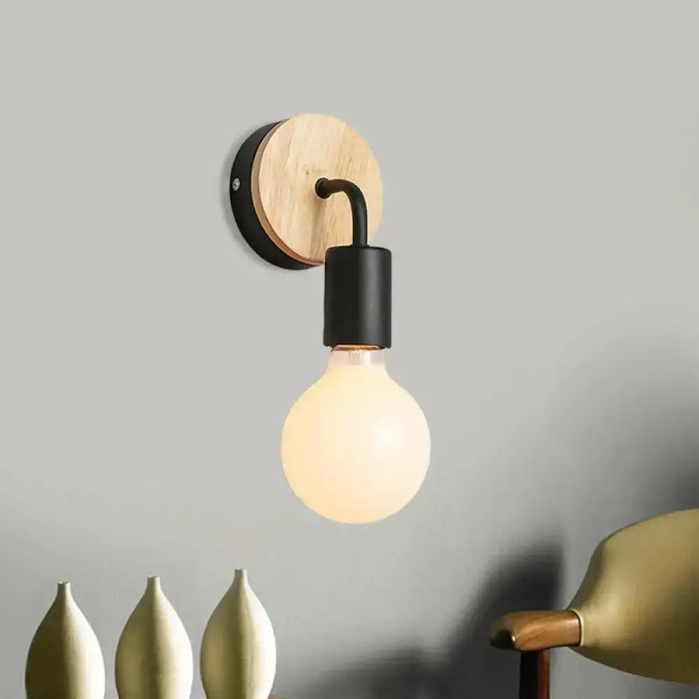Minimalist white and wood wall sconce with round wooden backplate black metal arm and direct wired electric light